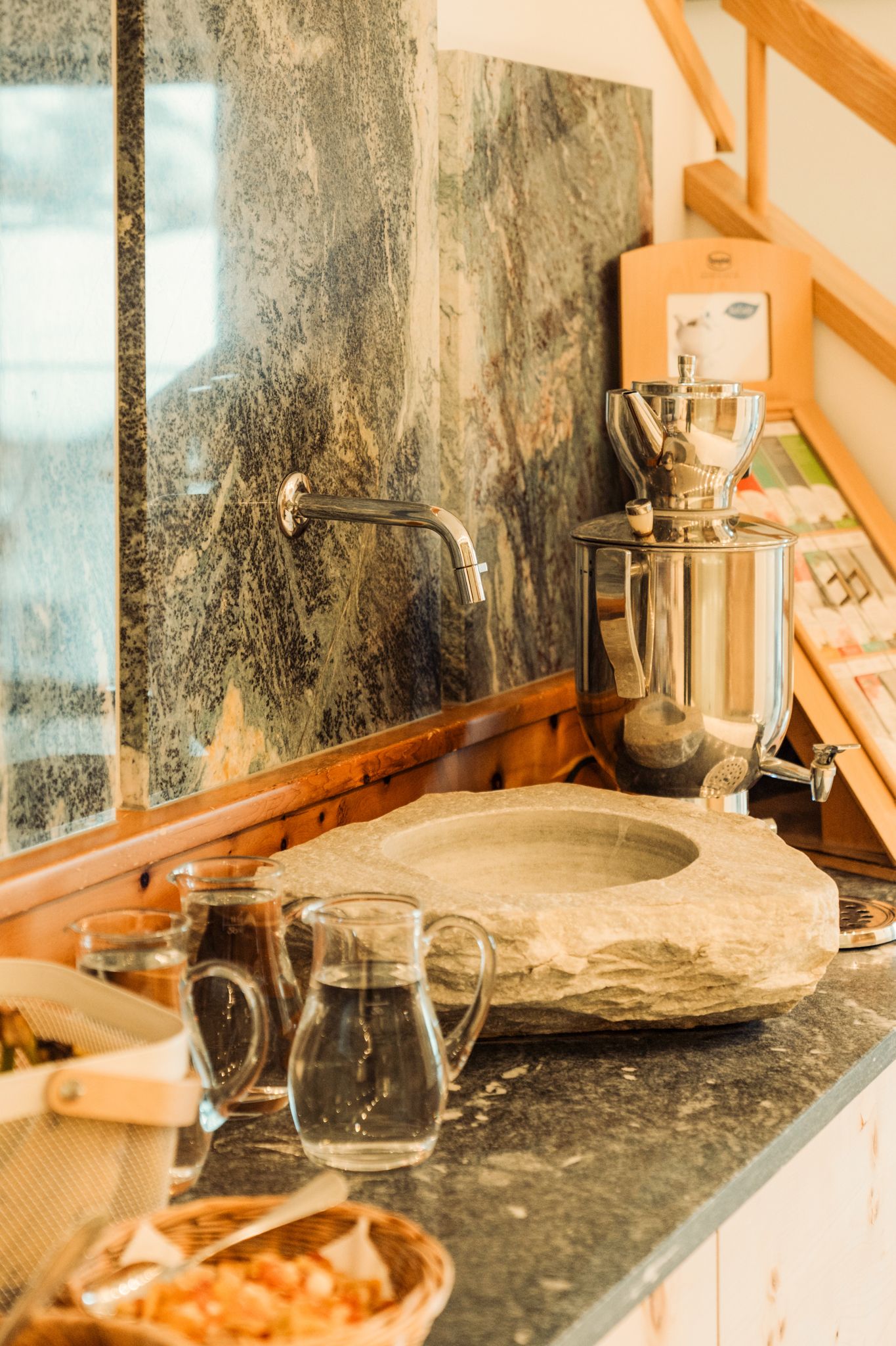 Ein stilvoller Bereich im Glemmtalerhof mit Steinschale und Glaskaraffen.