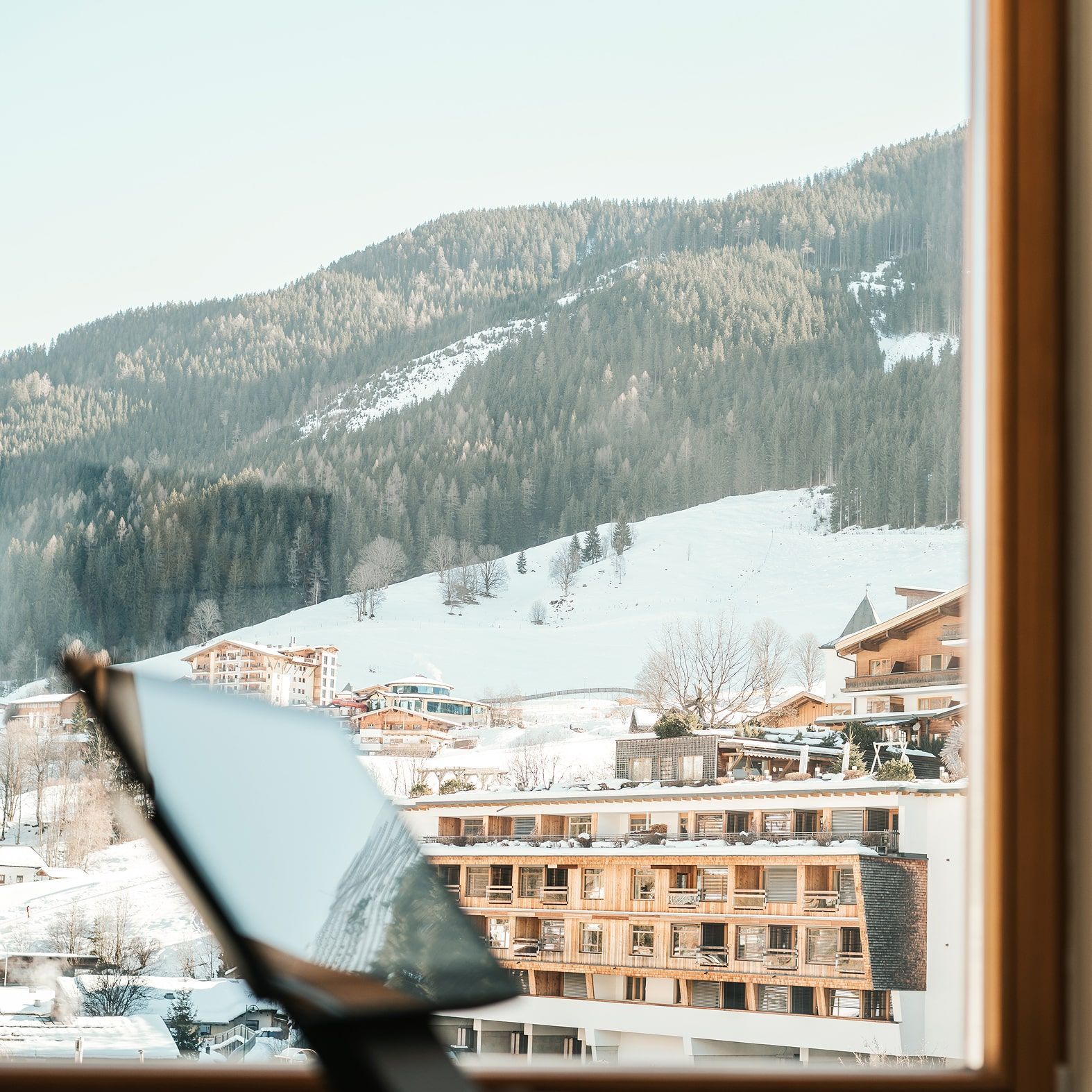 Gipfelblick über das verschneite Glemmtal mit dem Glemmtalerhof in Hinterglemm im Vordergrund.
