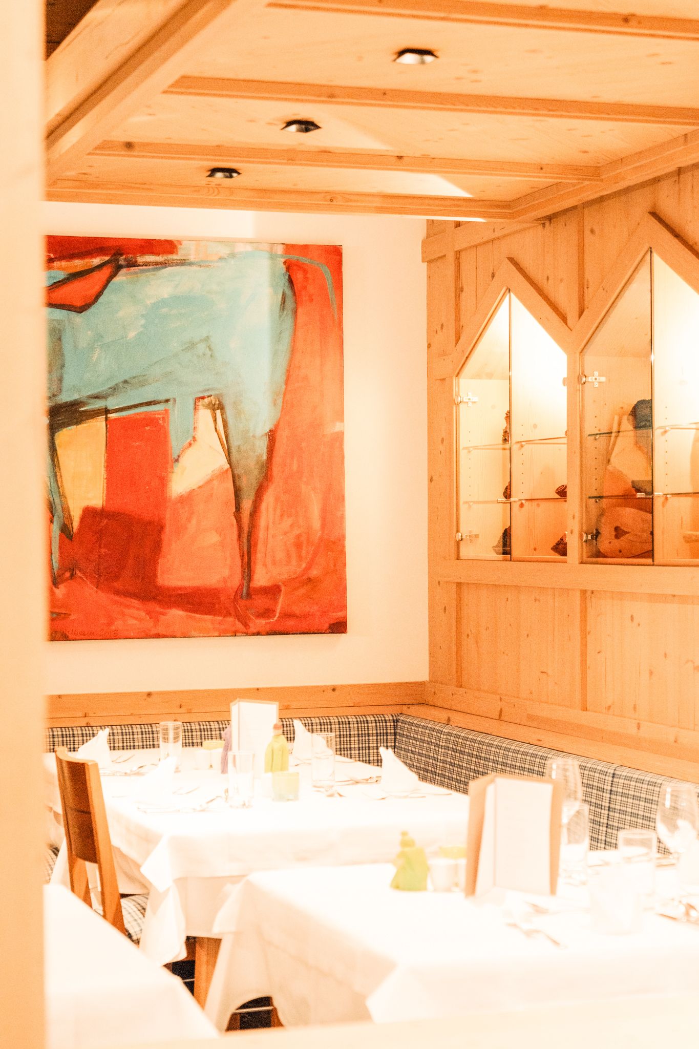 Ein stilvolles Restaurant im Glemmtalerhof mit modernem Kunstwerk und gemütlicher Atmosphäre.