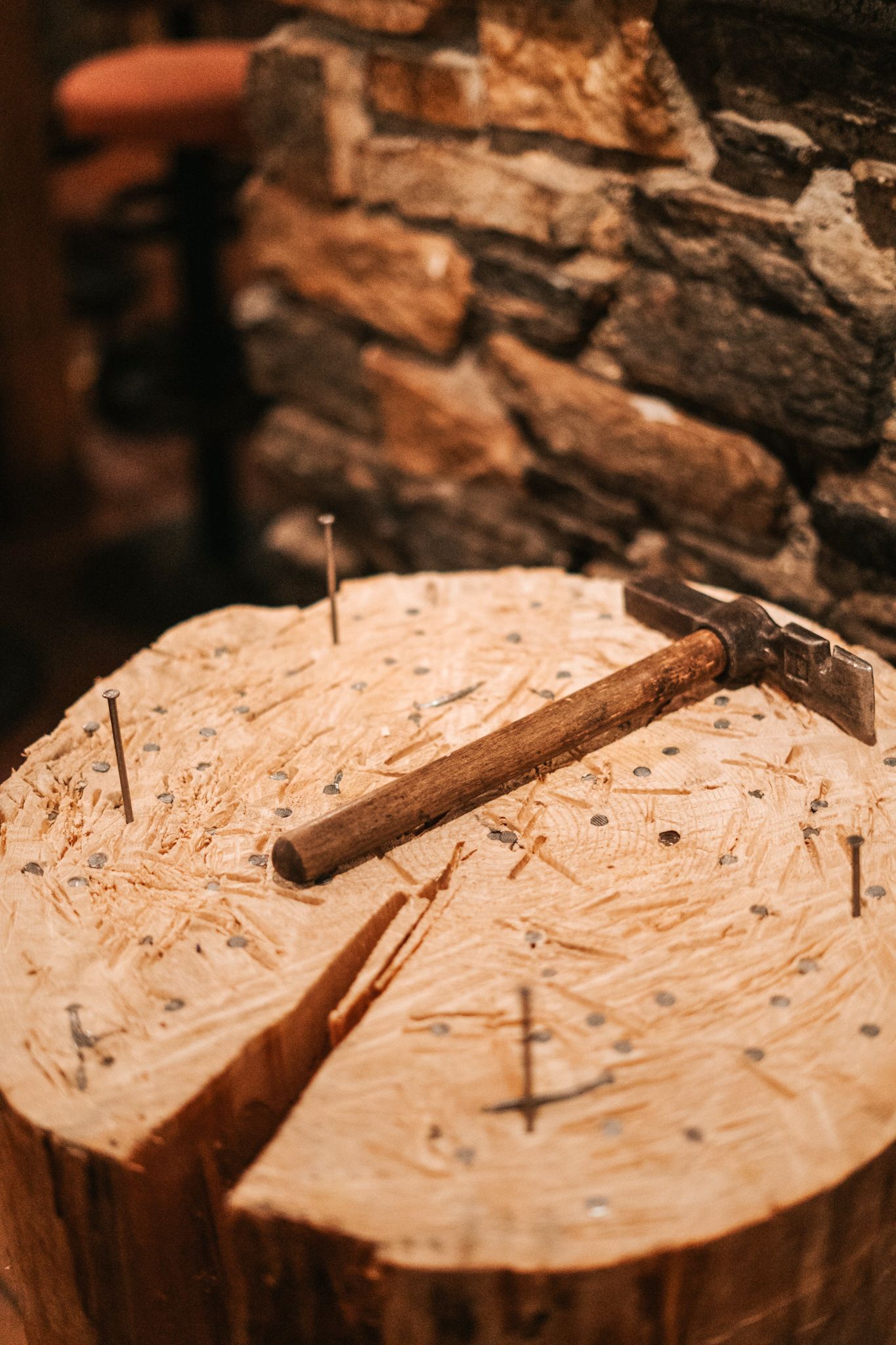 Ein Holzstück mit einem Hammer und mehreren Nägeln im Glemmtal.