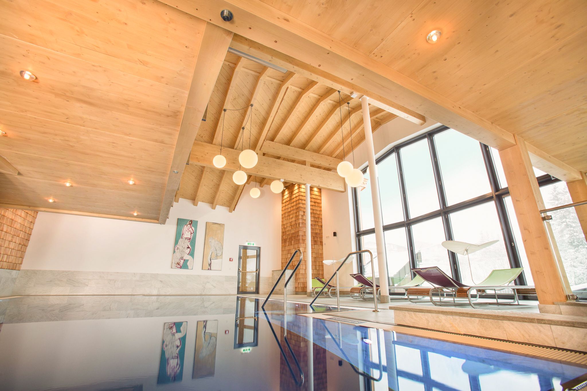 Ein moderner Wellnessbereich im Glemmtalerhof mit Holzdetails und einem einladenden Pool.