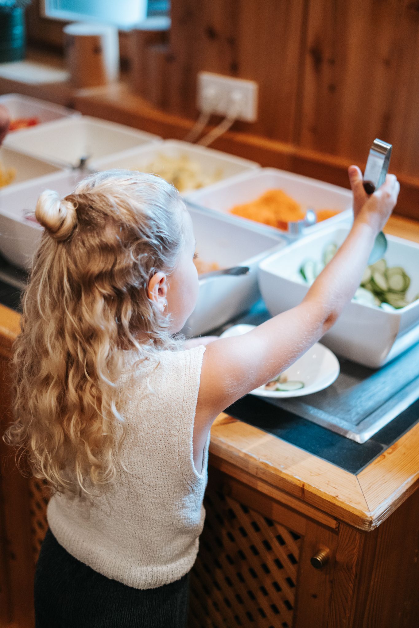 Ein Mädchen wählt gesunde Snacks im Glemmtalerhof in Hinterglemm.
