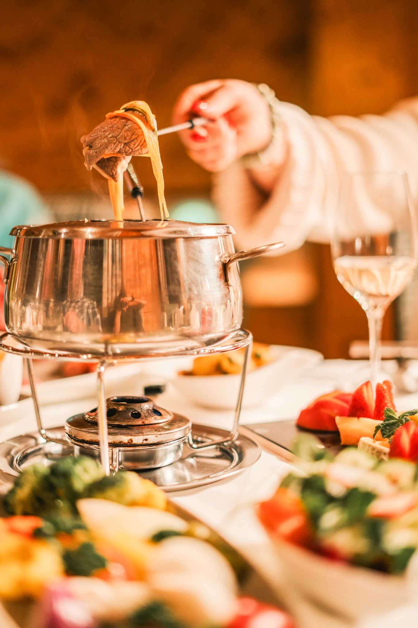 Ein köstliches Fondue im Glemmtalerhof, umgeben von frischem Gemüse und einer feinen Atmosphäre.