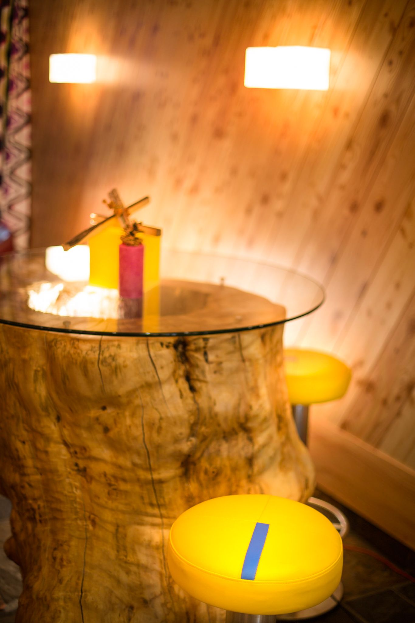 Ein gemütlicher Tisch aus Holz und bunte Stühle im Glemmtalerhof in Hinterglemm.