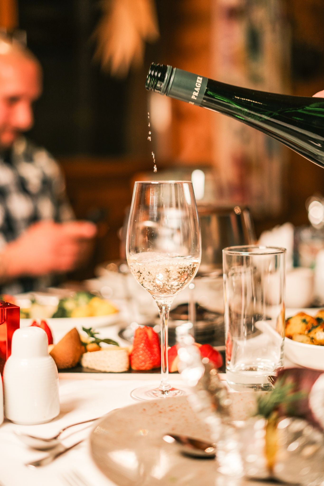 Im Glemmtalerhof in Hinterglemm wird prickelnder Sekt einschenkt. Leckereien auf dem Tisch runden das Erlebnis ab.