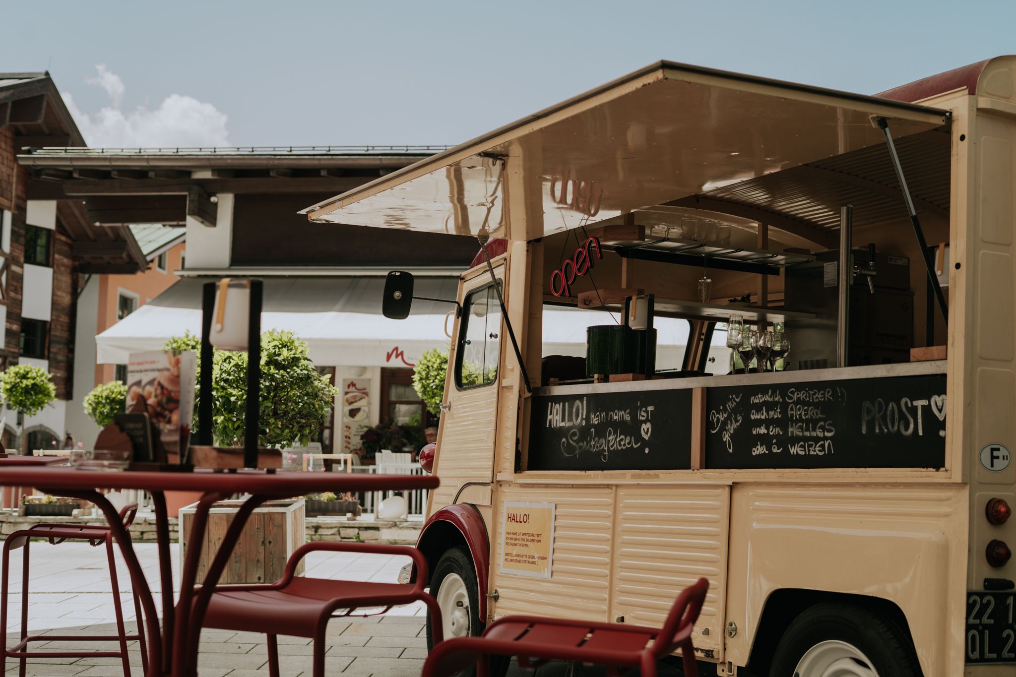Glemmtalerhof in Hinterglemm zeigt ein offenes Restaurantfahrzeug mit netter Atmosphäre und bunten Stühlen.