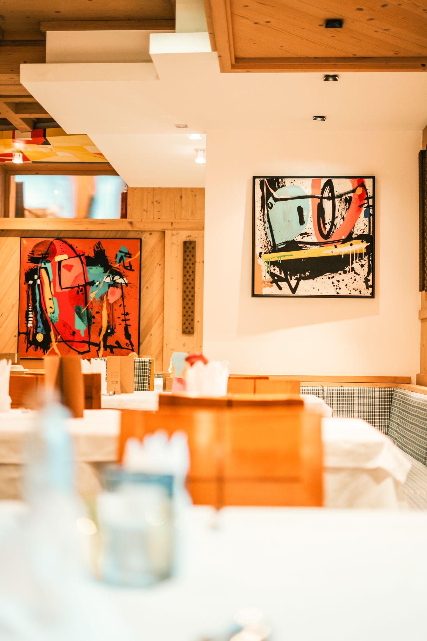 Ein stilvolles Restaurant im Glemmtalerhof mit modernen Kunstwerken an den Wänden.