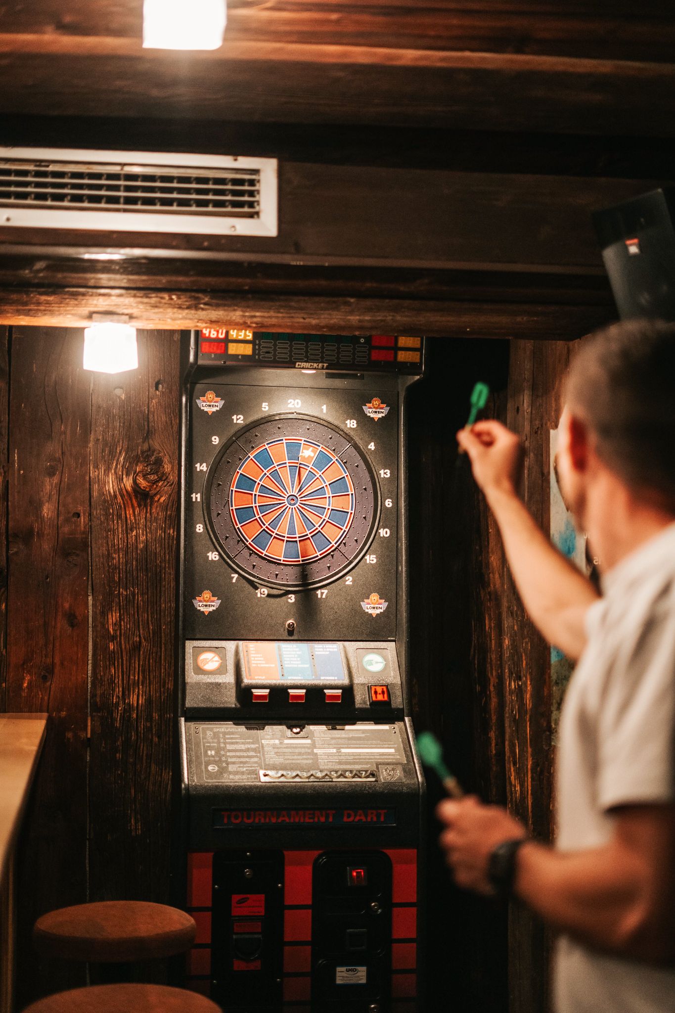 Ein Spieler wirft ein Dart auf eine elektronische Dartscheibe im Glemmtalerhof in Hinterglemm.