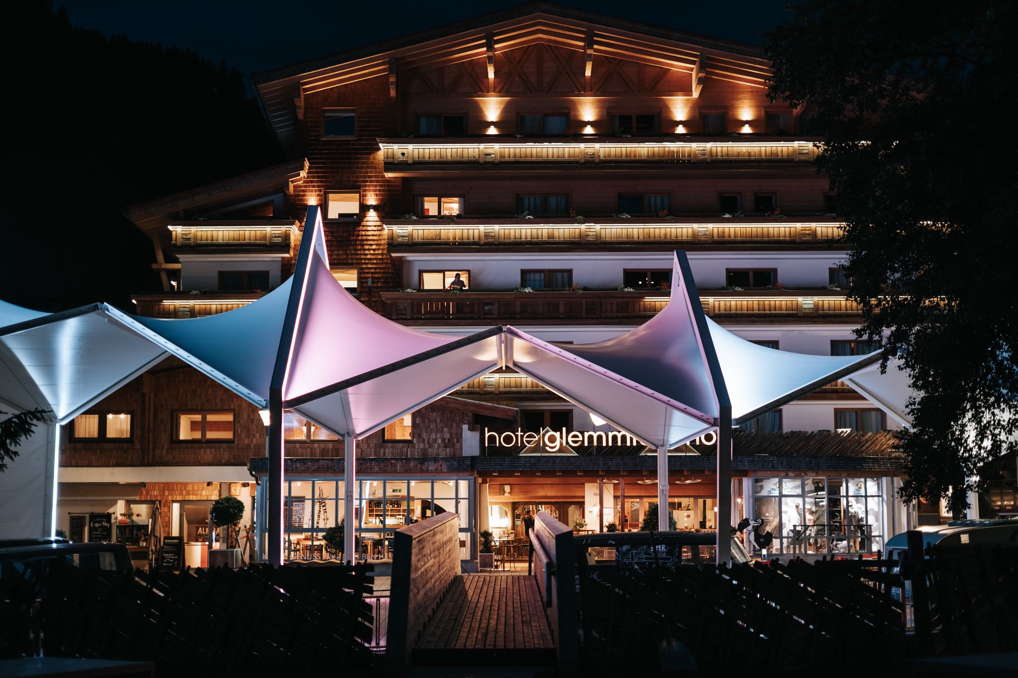 Glemmtalerhof im Hinterglemm leuchtet bei Nacht mit bunten Lichtern.