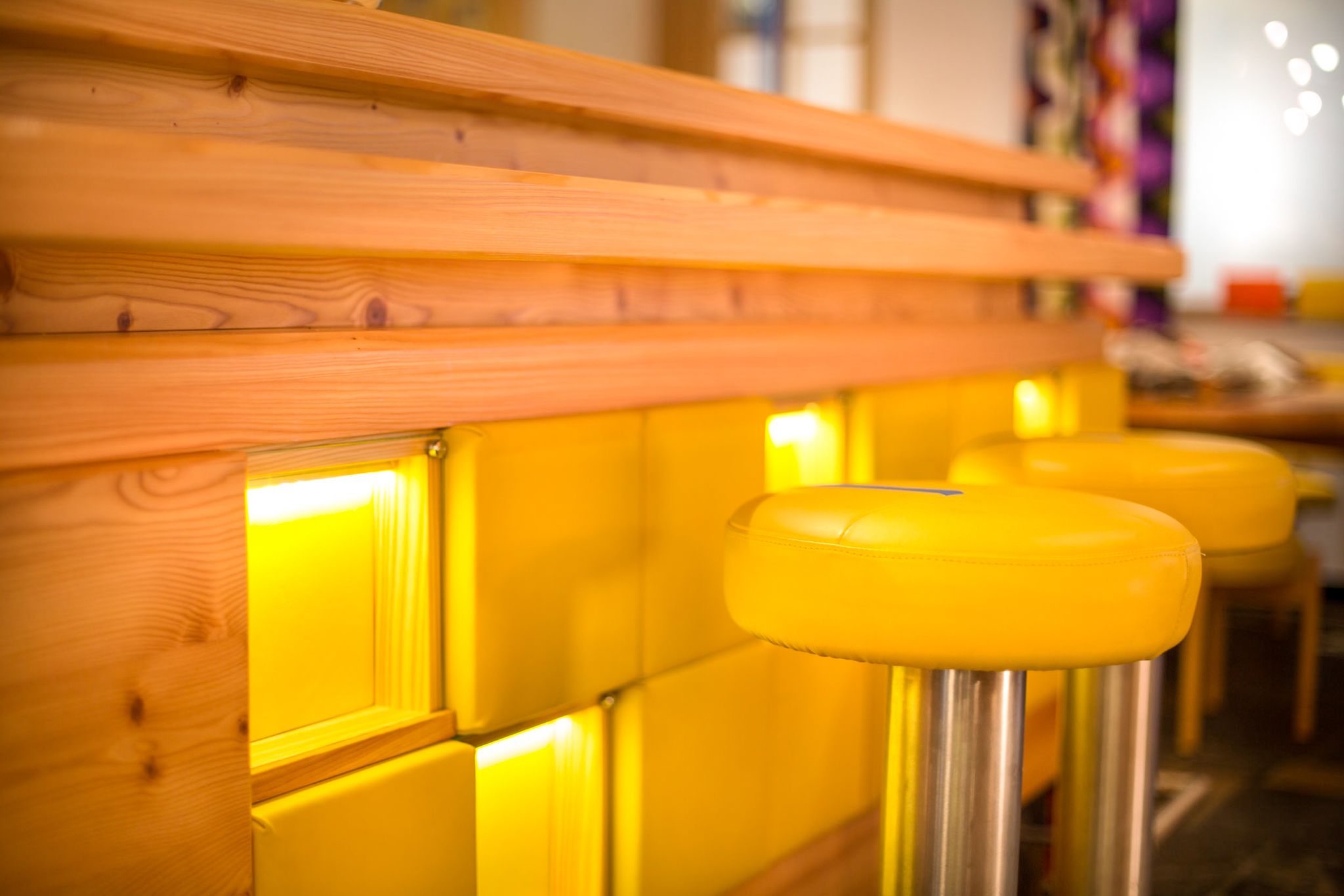 Die Bar im Glemmtalerhof in Hinterglemm hat ein modernes, warmes Design mit gelben Stühlen.