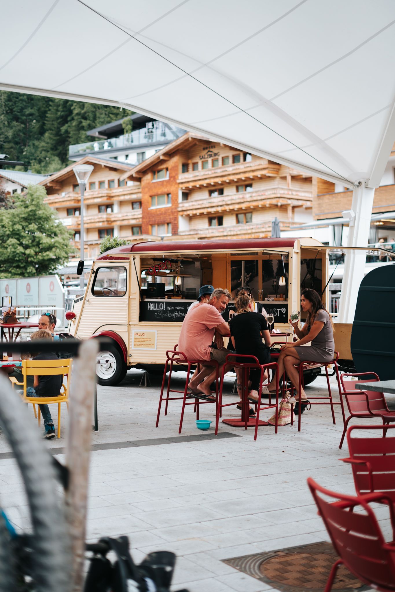 Gäste genießen Essen und Trinken vor dem Glemmtalerhof in Hinterglemm.