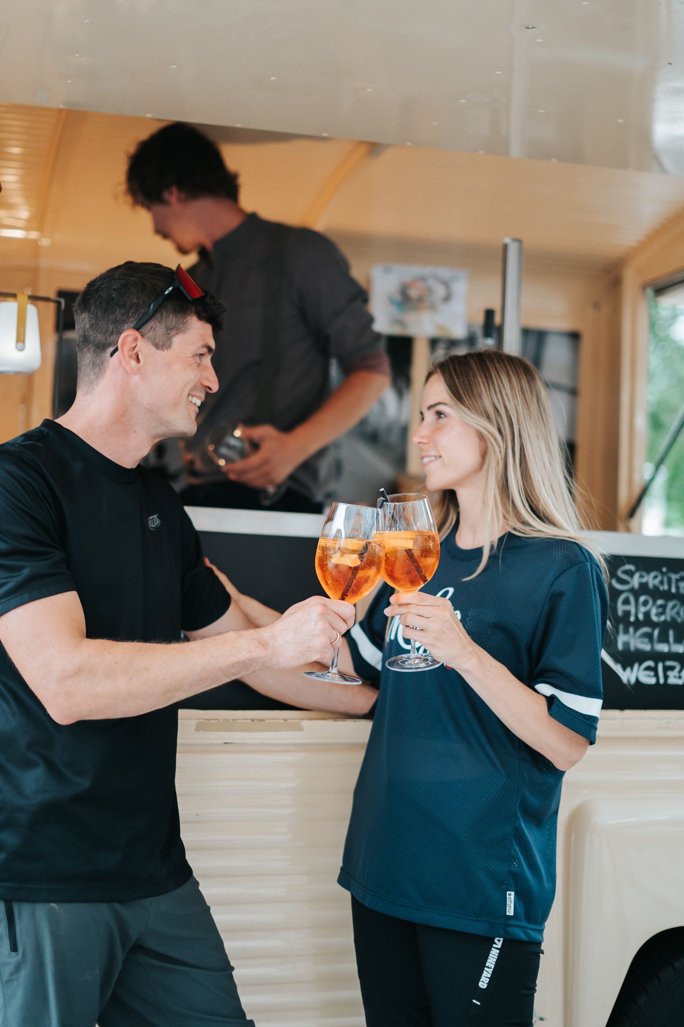 Im Glemmtalerhof in Hinterglemm stoßen zwei Menschen mit Getränken an. DE