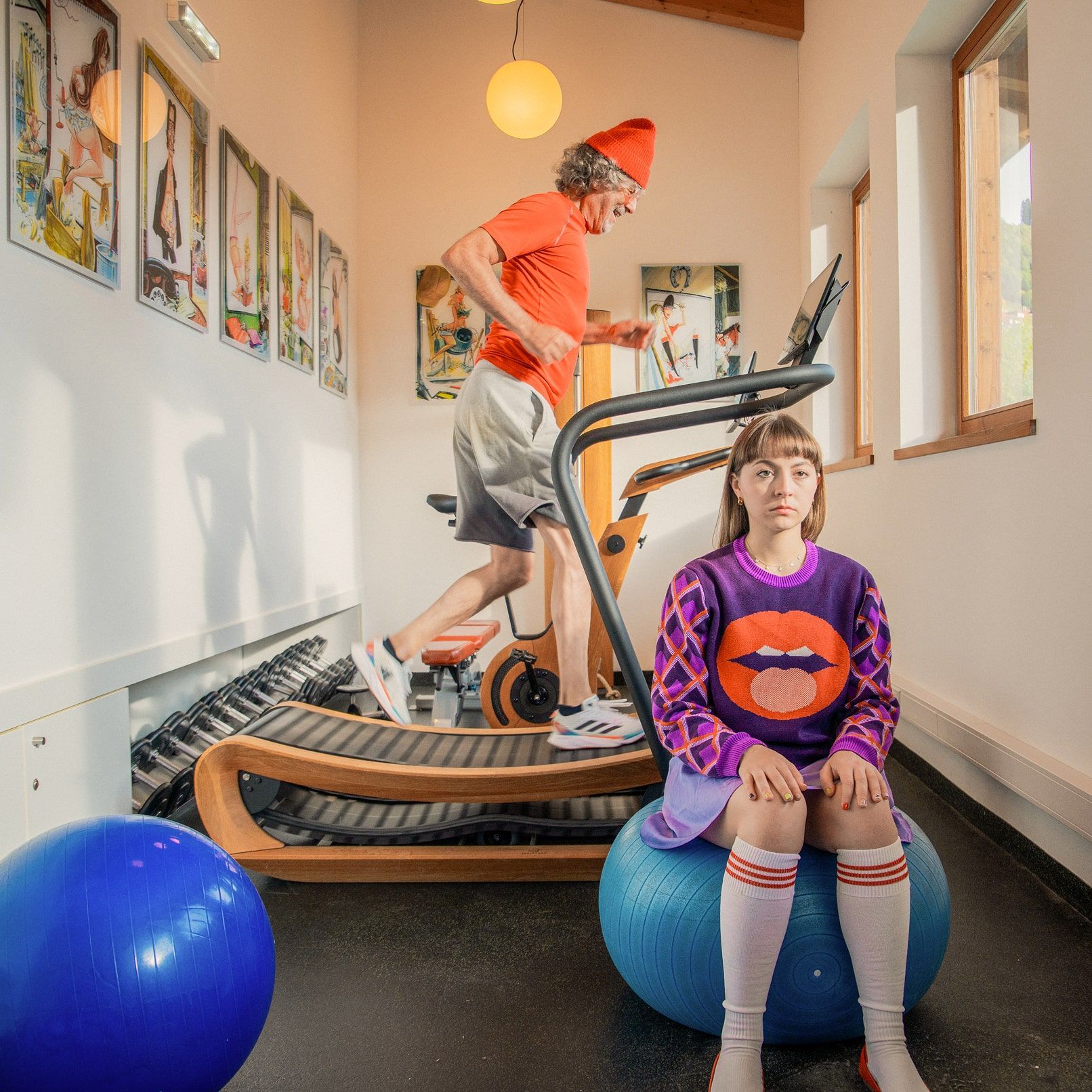 Im Fitnessraum des Glemmtalerhofs läuft ein Mann auf einem Laufband. Eine Frau sitzt auf einem Gymnastikball.