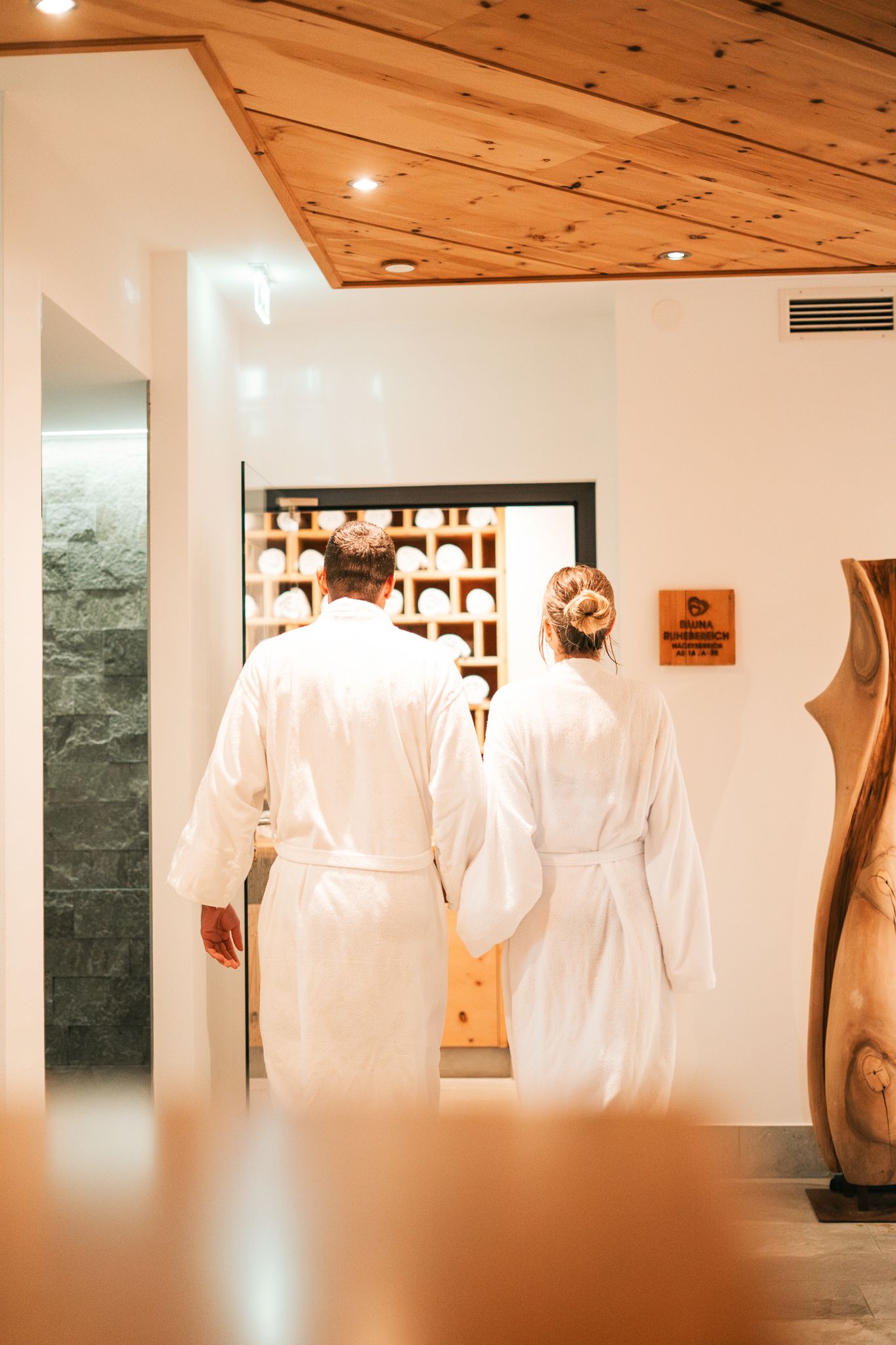 Im Glemmtalerhof in Hinterglemm betreten zwei Personen entspannt den Wellnessbereich.